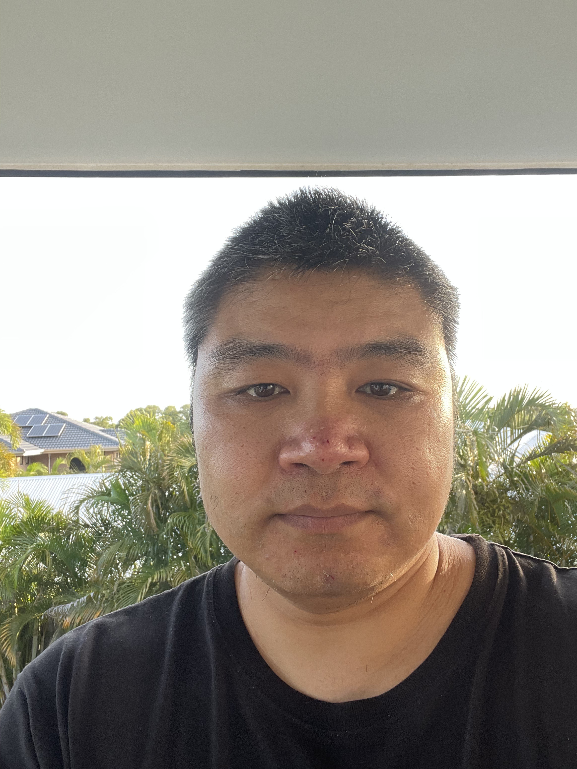 Portrait of Matthew on a balcony in front of palm trees