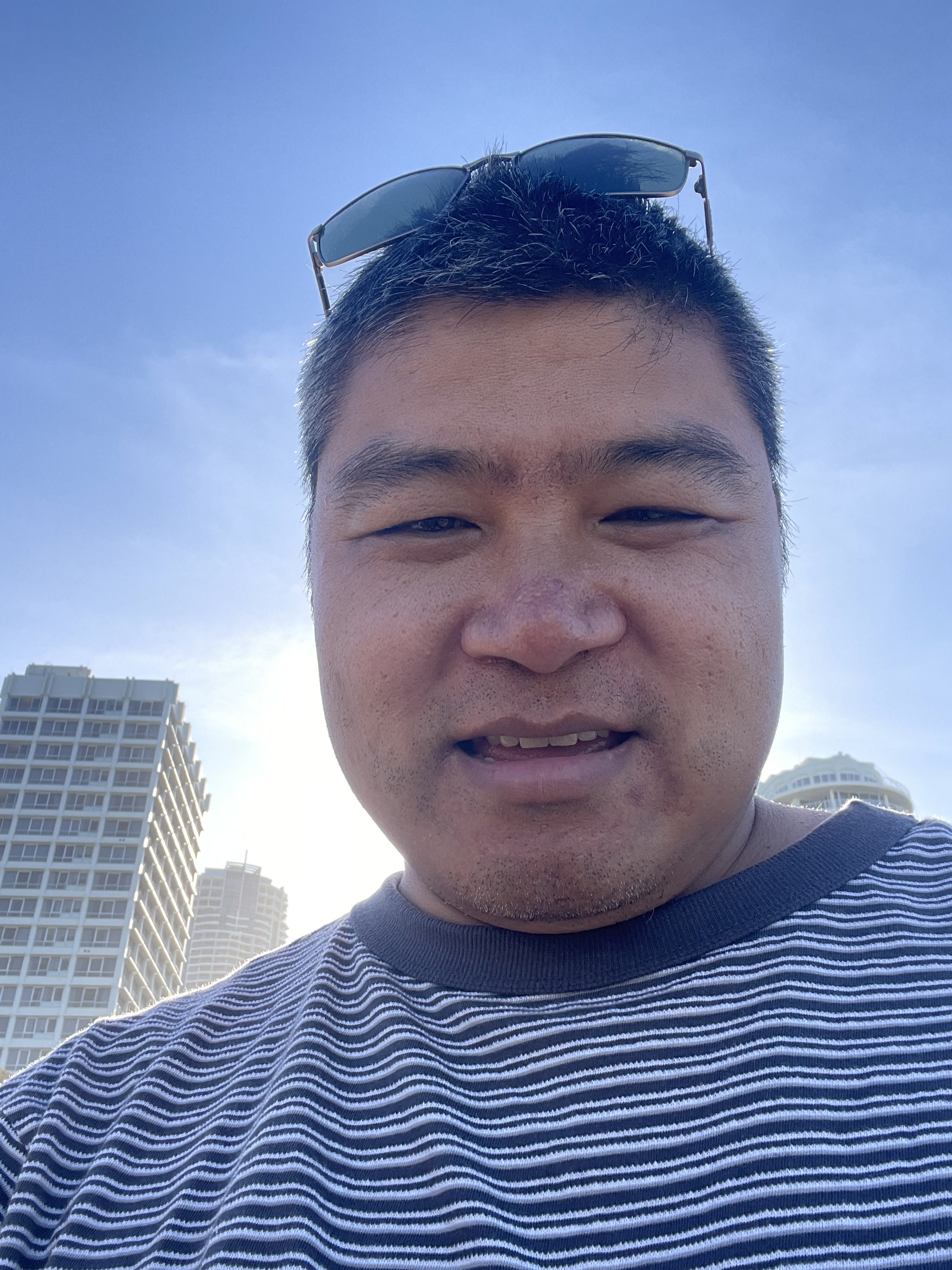 Matthew taking a city selfie under a blue sky