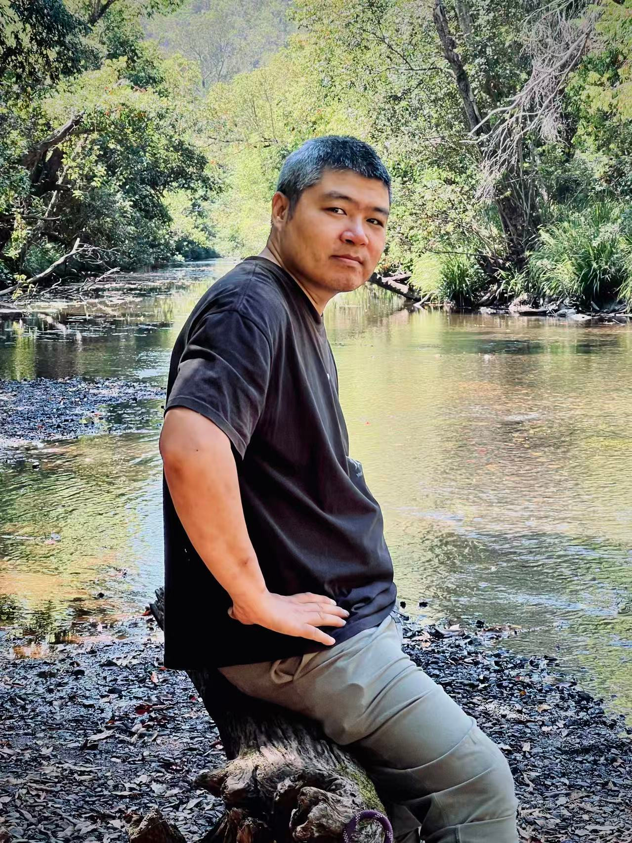 Matthew sitting beside a creek in the forest